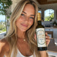 Woman holding a bottle of organic extra virgin olive oil in a kitchen setting